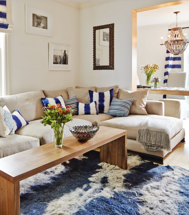 Ъглов диван със сини и бели възглавници в цвета на завесите