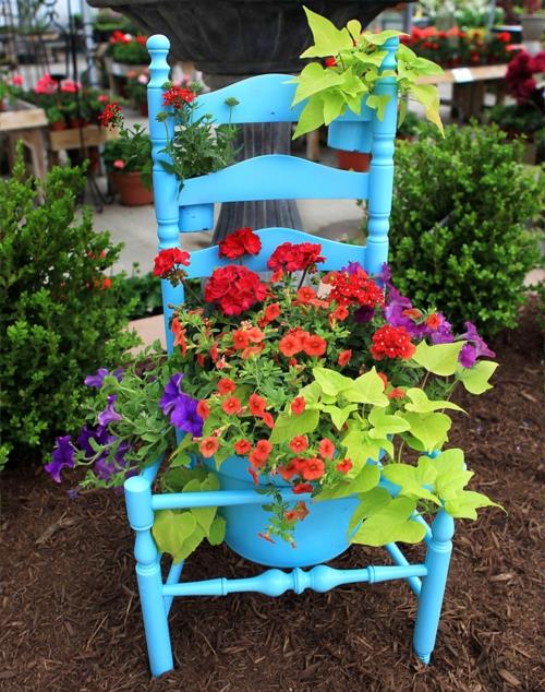 Stare krzesła w ogrodzie z nowymi, atrakcyjnymi niebieskimi doniczkami