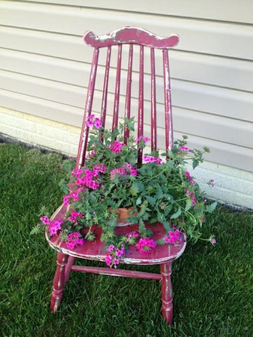 Stare krzesła w ogrodzie z nowymi, atrakcyjnymi donicami z różowego drewna