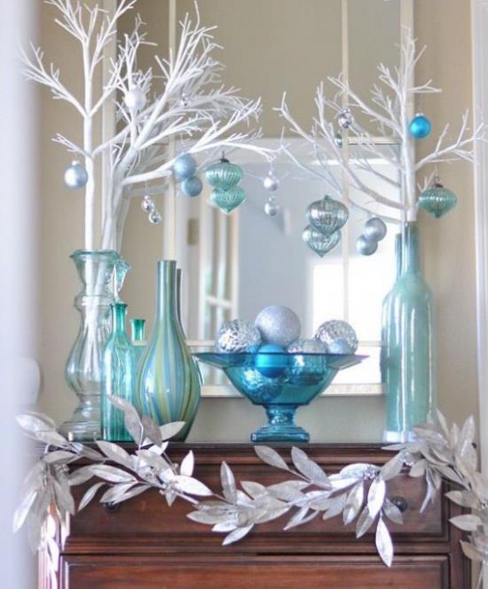 Niebieskie i srebrne uroczystości bożonarodzeniowe i noworoczne dekoracje aranżacja wazony białe gałązki wisiorki girlanda ze srebrnych liści