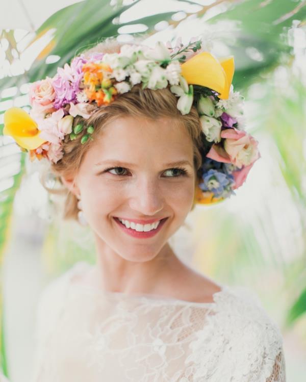 Fryzura ślubna z kwiatami przypiętymi kolorowym wieńcem kwiatowym