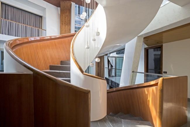 Unikalny projekt domu Cleft House India New Delhi pomysłowe eleganckie spiralne schody w atrium ułatwiają dostęp do wyższych pięter