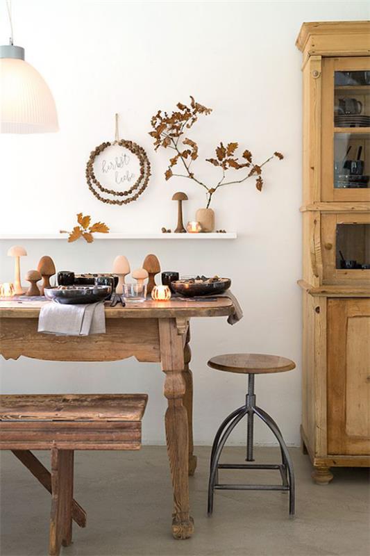 Salle à manger décorer automnale table à manger décorer dans un style rustique petites branches en bois dans un vase banc de table en bois