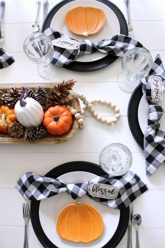 Décorez la salle à manger dans une table à manger automnale décorez le look classique citrouilles colorées très élégantes pommes de pin à chaîne blanche dans un bol en bois serviettes à carreaux blanc-noir