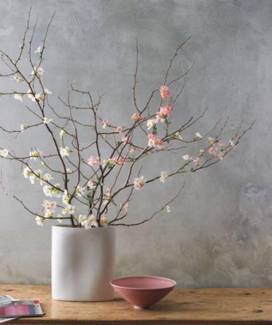 Wiosenna dekoracja z kwiatami wiśni minimalistyczny design biały wazon białe i różowe kwiaty mała różowa miska obok niej