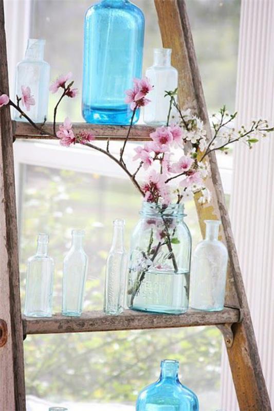 Wiosenna dekoracja z kwiatami wiśni dwie trzy gałęzie różowych kwiatów w szkle na starej drewnianej drabinie