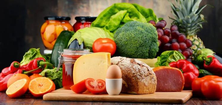Zdrowa i zbilansowana żywność w czasach kryzysu koronowego, dużo owoców, warzyw, orzechów, chleba, mięsa, kiełbasy, jajek, serów, miodu