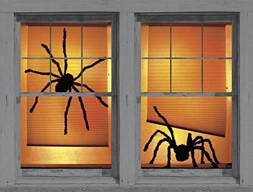 Halloween dekoracja okna dwa duże czarne pająki pomarańczowe tło dobrze oświetlone.