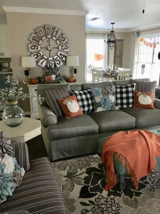 Les décorations d'automne dans le salon combinent le gris avec l'orange et le marron clair pour pimenter la pièce