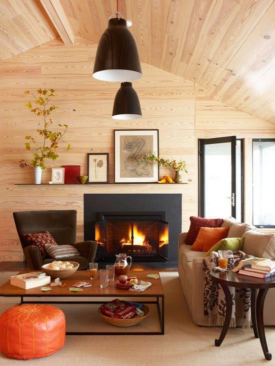 Décoration d'automne dans le salon, plafond en bois, feu brûlant dans la cheminée, couleurs chaudes tout autour, très cosy et cosy