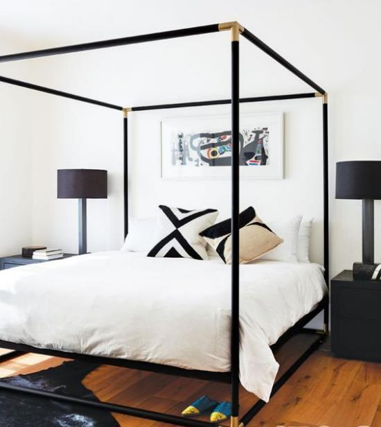 Łóżko z baldachimem powlekana na czarno metalowa konstrukcja kontrastuje z białą czernią