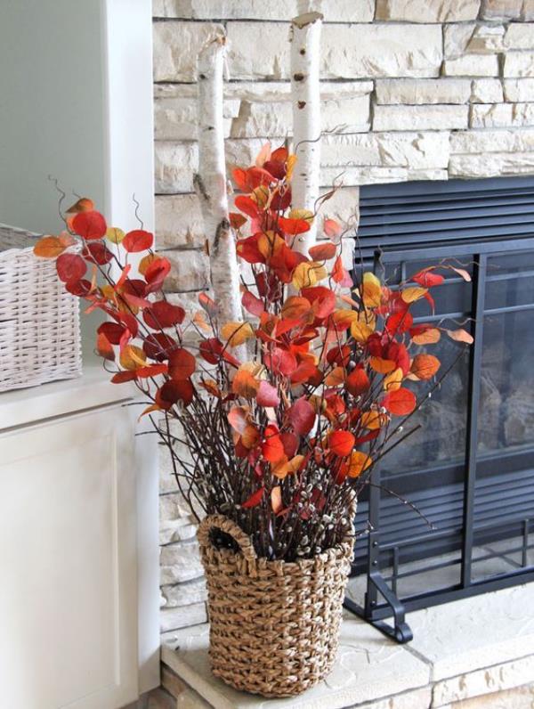 Adorables idées de décoration d'automne avec des feuilles colorées dans un panier en osier disposé de fines branches