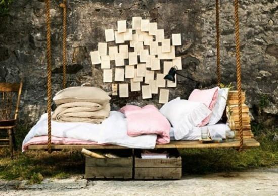 Łóżko wiszące na zewnątrz w ogrodzie książki do czytania pościeli do spania kamienna ściana ozdobiona nutami papieru