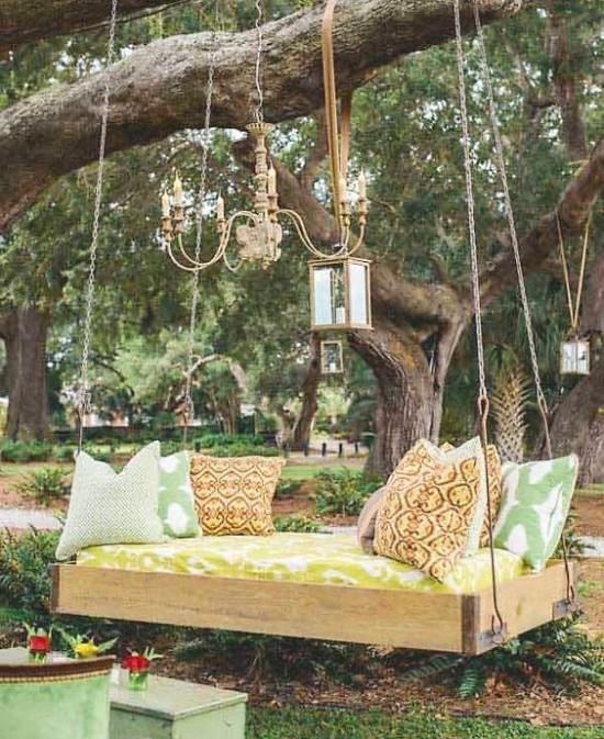 Wiszące łóżko na zewnątrz w ogrodzie zieleń latarnie żyrandol w stylu retro