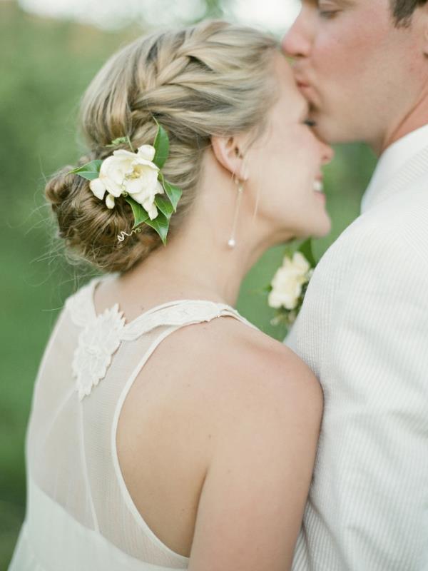Fryzury ślubne z kwiatami kok pleciona fryzura biały wiosenny kwiat