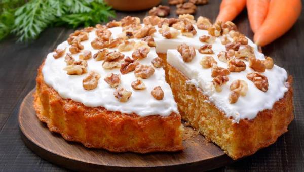 Gâteau aux carottes un incontournable du menu de Pâques, juteux et délicieux, cuit dans un moule à charnière avec du fromage à la crème et des noix sur le dessus