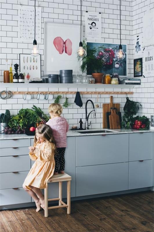 Aneks kuchenny w stylu retro jasnoniebieskie szafki dwa małe dziecięce taborety warzywa na blacie