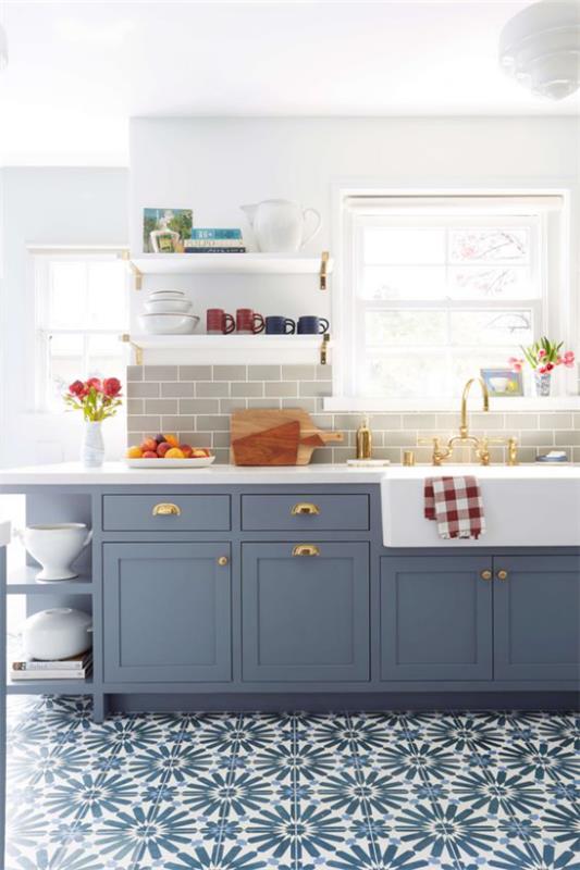 Aneks kuchenny w stylu retro wzorzyste płytki podłogowe w niebieskich pastelowych niebieskich szafkach dolnych okno dużo jasnych kolorowych plam owocowych