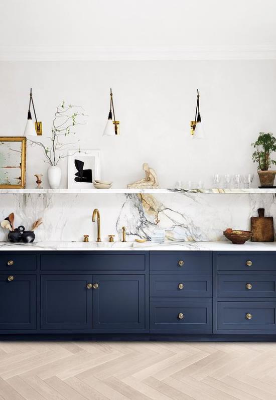 Aneks kuchenny nowoczesny design kontrastuje kolorami granatowe szafki dolne białe marmurowe elementy dekoracyjne górnej półki
