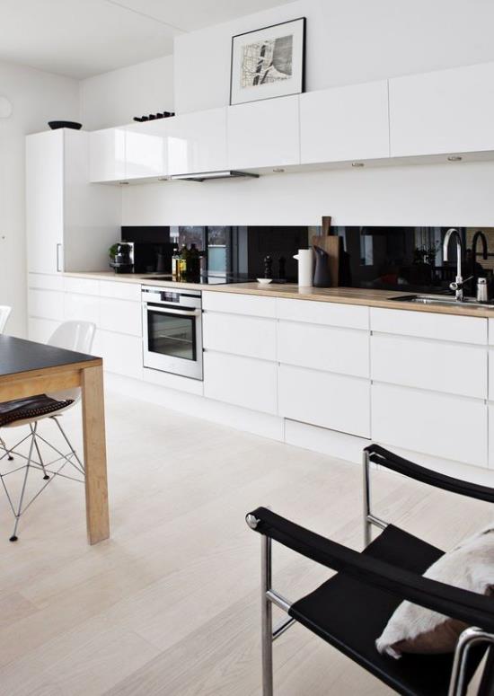 Aneks kuchenny nowoczesny projekt kuchni w kolorze białym super elegancki czarny kontrast kolorystyczny tylnej ściany kuchni