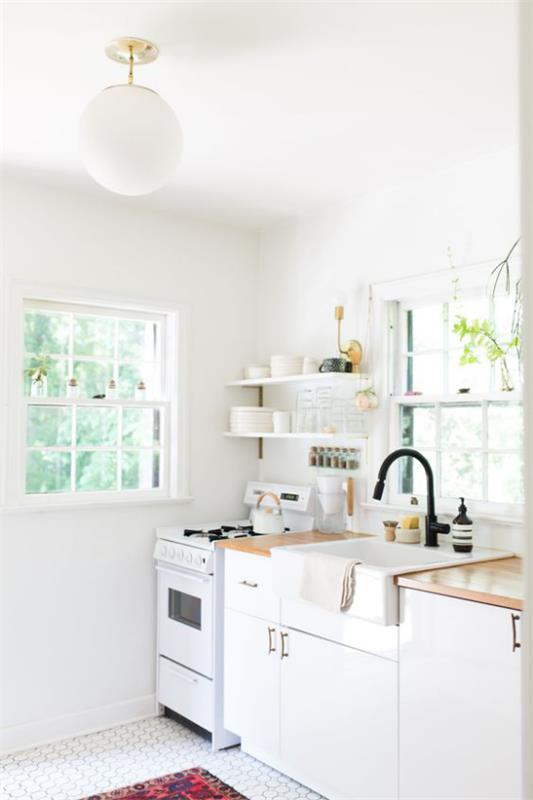 Kuchnia od ściany do ściany w kolorze białym w stylu retro półka dwa okna
