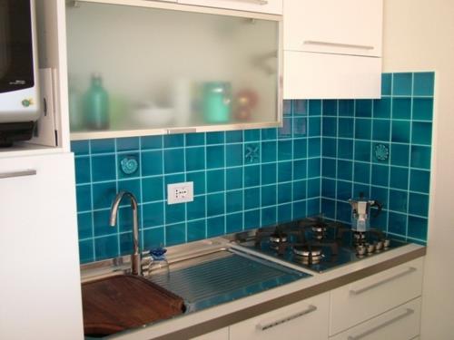 Kompaktowe meble kuchenne ciemnoniebieskie płytki kuchnia tylna ściana
