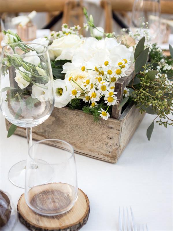 Marguerites dans une boîte en bois arrangé des décorations de table dans un style rustique