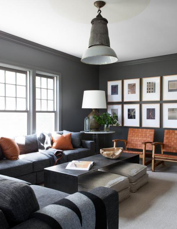 Męski i elegancki nowoczesny salon w szarej kolorystyce akcentuje ścianę obrazami o wysublimowanym stylu