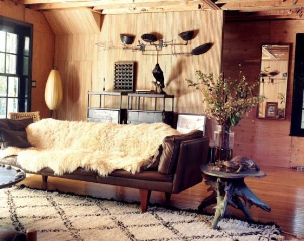 Męski i elegancki nowoczesny salon w ciepłych odcieniach brązu, beżowego futra, dużo drewna