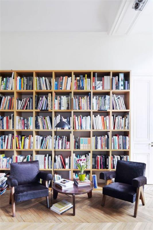 Bibliothèque à la maison moderne coin lecture deux fauteuils petite table beaucoup de livres