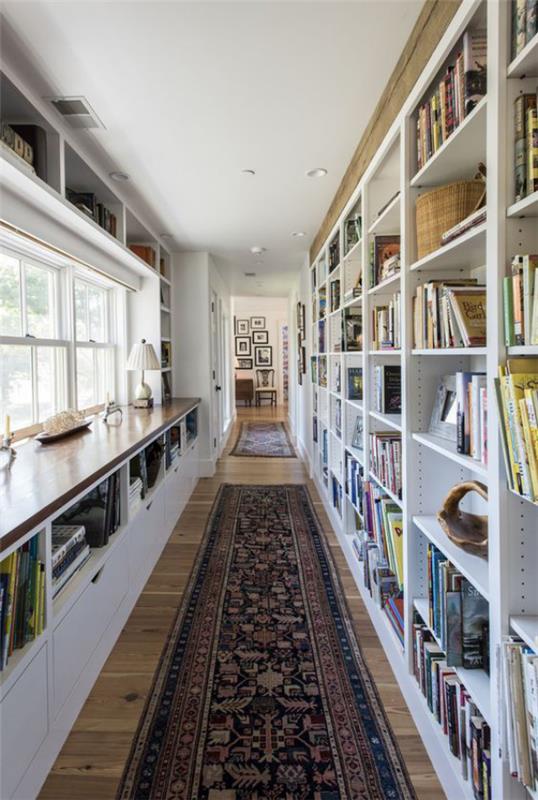 Bibliothèque à la maison moderne, longue et étroite, beaucoup de fenêtres lumineuses ont laissé des coureurs sur le sol