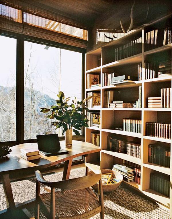 Bibliothèque de maison moderne dans des tons de bois chauds, beaucoup de lumière naturelle