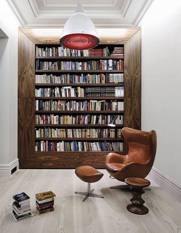 Bibliothèque à la maison moderne, conception classique de mur de livre, fauteuil en cuir devant