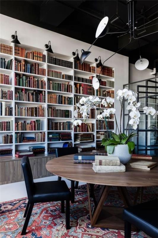 Table ronde de bibliothèque à la maison moderne assise orchidées blanches assorties à la lumière
