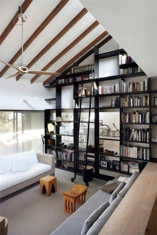 Bibliothèque à la maison moderne étagères noires meubles blancs sous le plafond en pente
