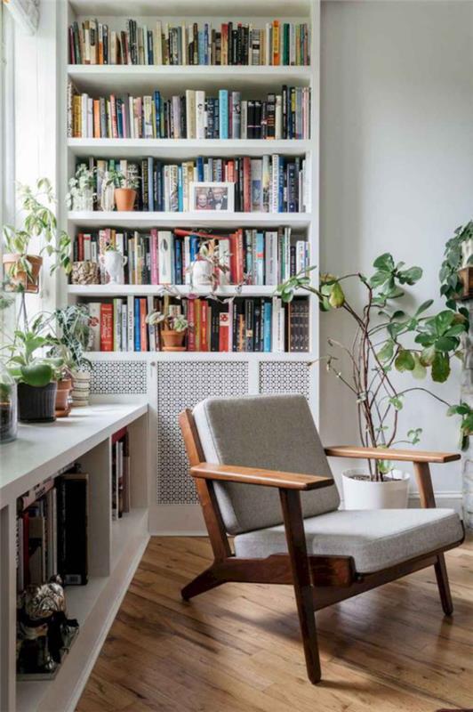 Bibliothèque à la maison moderne beaucoup de lumière naturelle Étagères de livres sur le mur sous la fenêtre