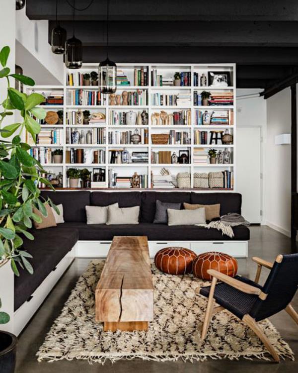 Bibliothèque de maison moderne entre classique et romantique, ambiance cosy, pouf en cuir, plante d'intérieur verte