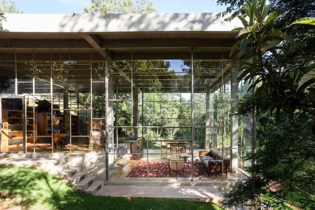 La maison moderne en verre et béton construite dans la forêt tropicale s'intègre harmonieusement dans l'environnement