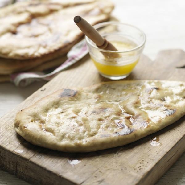 Cuire le pain naan, badigeonner de beurre