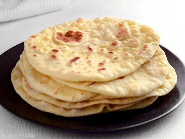 Cuire le pain naan et l'empiler sur l'assiette