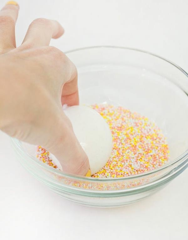 Peignez les œufs de Pâques et saupoudrez-les de bâtonnets de boulangerie colorés