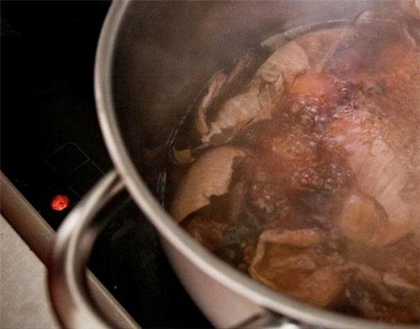 Pâques peignant des oeufs colorés dans un pot d'eau chaude immerger