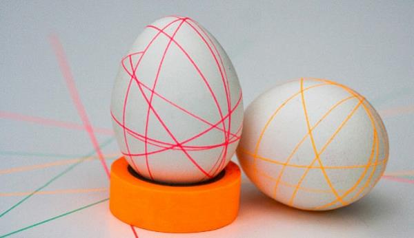 Peignez les oeufs de Pâques avec du ruban adhésif coloré et des lignes géométriques colorées