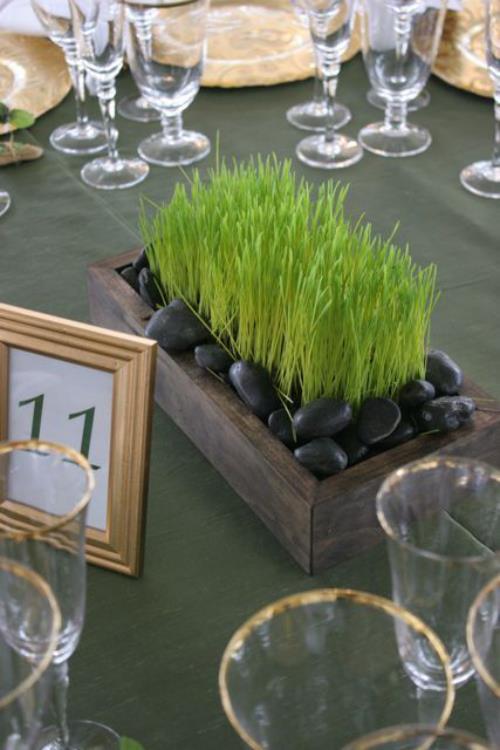 Semez vous-même de l'herbe de Pâques dans une boîte en bois décorée de pierres noires sur la table qui attire le regard