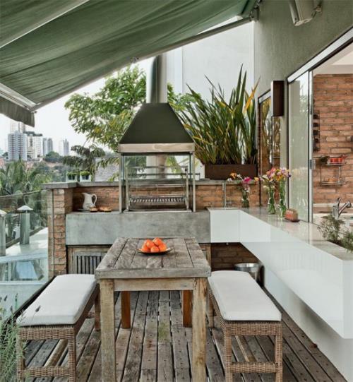 Cuisine extérieure moderne et rustique dans une table en bois bancs auvent de plancher en bois