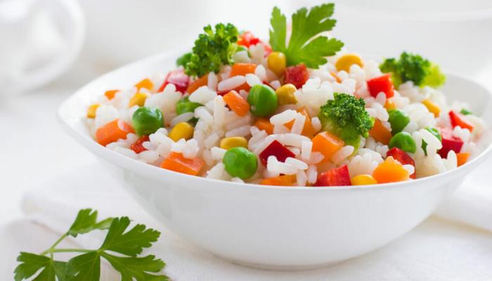Régime de riz Le riz cuit avec des légumes dans un bol blanc a bon goût est sain