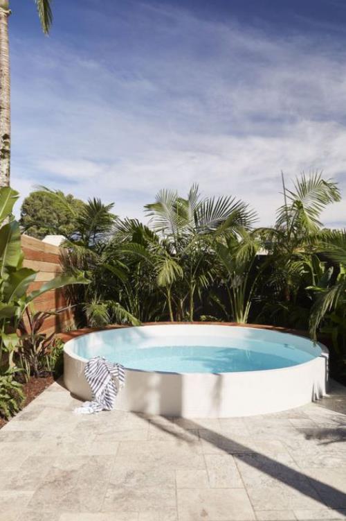 Okrągłe baseny ogrodowe Basen na podwórku, bujne zielone palmy jako ekran prywatności, uczucie dżungli?