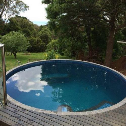 Okrągłe baseny ogrodowe okrągły basen i brodzik na podwórku idealny kształt schody tarasowe wśród zieleni