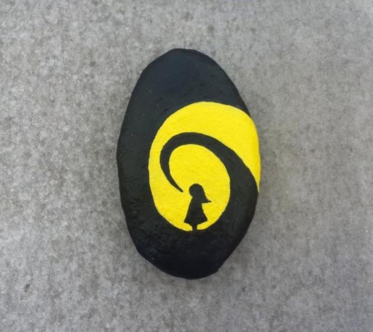 Maluj kamienie czarna żółta dziewczyna robiąca rękodzieło z kamieniami