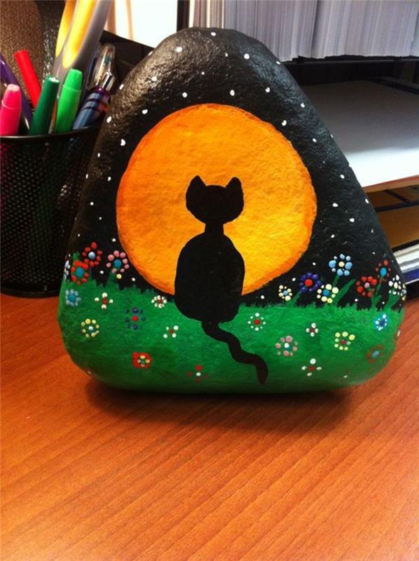 Czarny kot maluje kamienie rękodzieło z kamieni